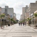 Calçadão requalificado no Centro de Curitiba com pedestres e prédios históricos